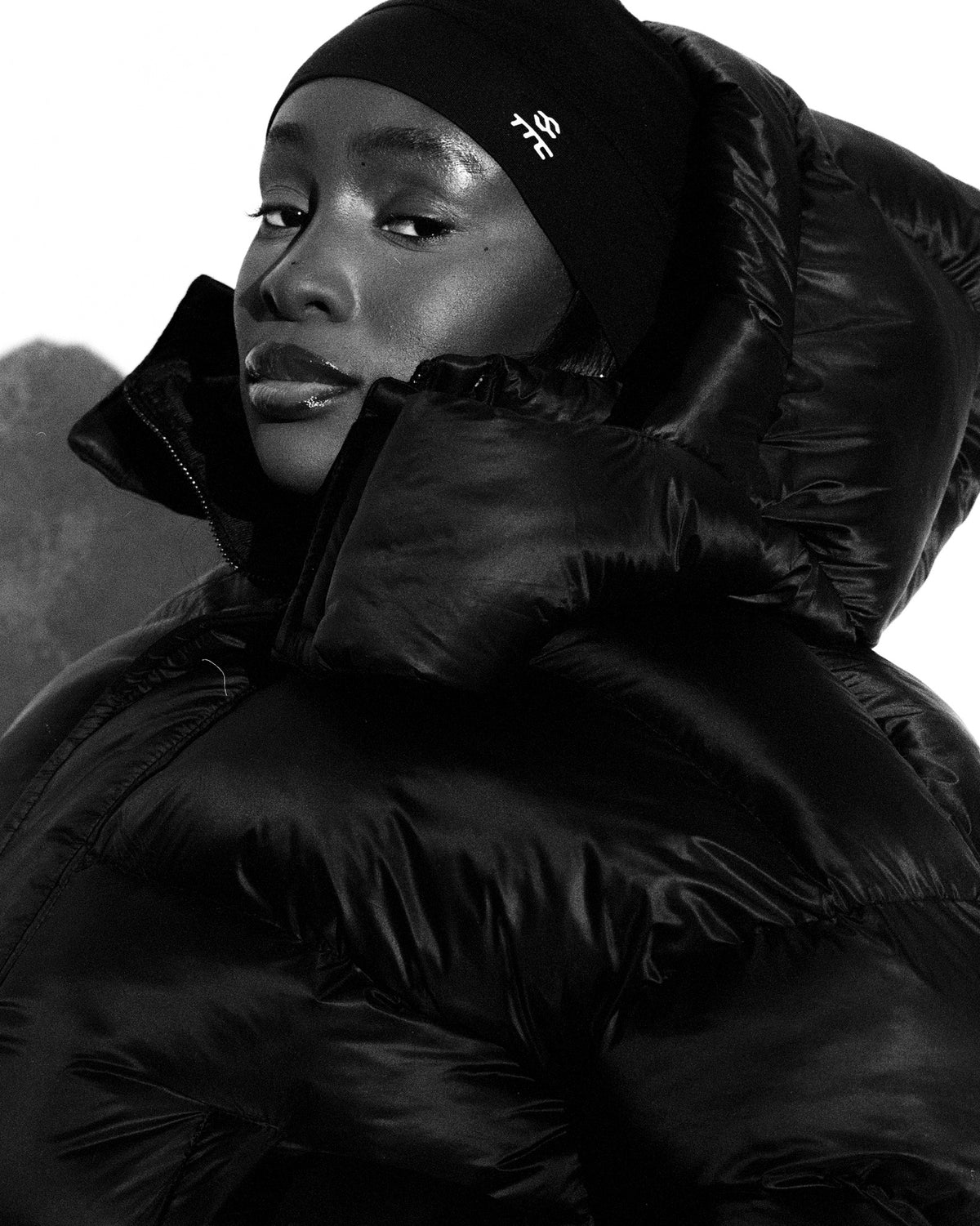 Harriet wearing the black OG Fleece Beanie with reflective TTC logo and Puffer Jacket