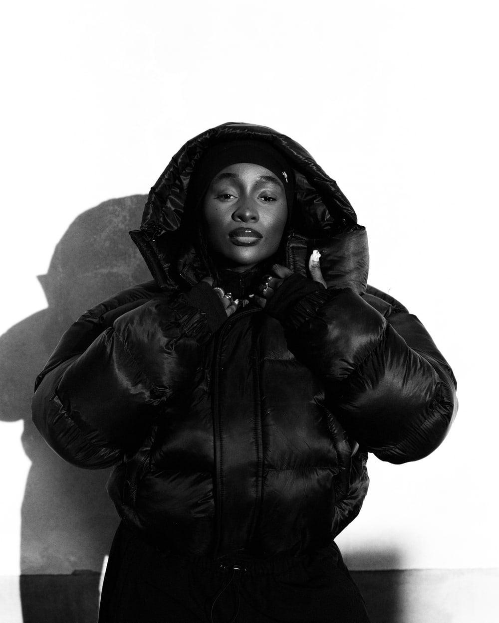 Puffer Jacket with hood up, photographed in hard sunlight